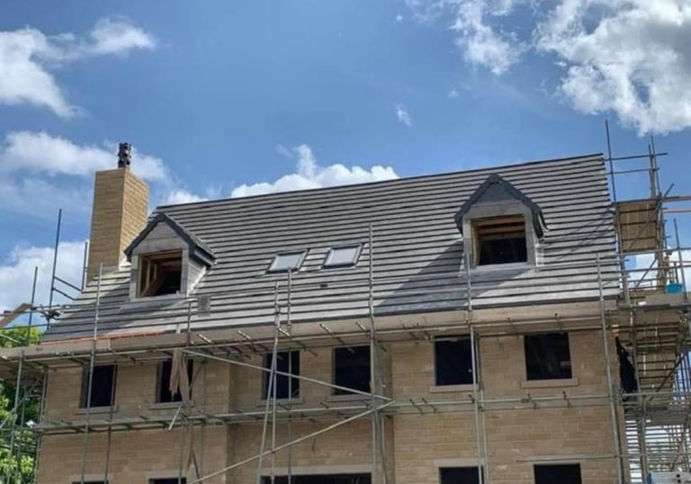 Roofing Specialist Yorkshire. showing a new roof being installed on a house with 2 dormer windows