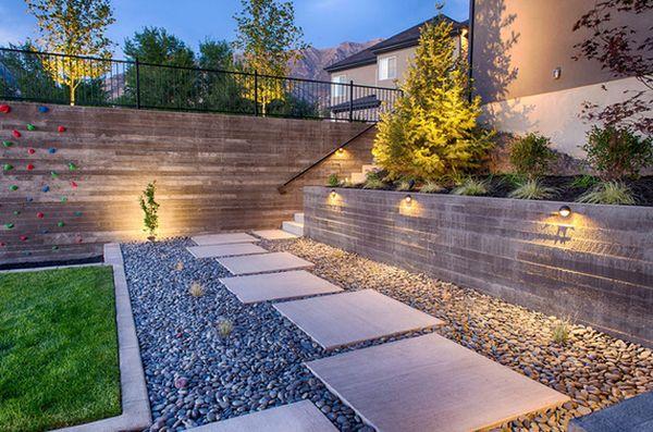 Decorative stone and gravel area leading from the house down steps with ambient lighting.