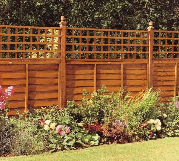 A new wooden garden fence bordering the property, with flowering plants in the bedding area and a fr