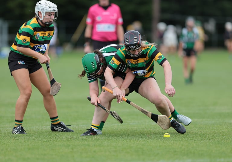 Camogie players battling for the sliotar on the ground