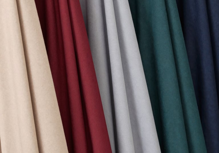 Close-up of delicate embroidery on a soft beige hijab draped over a wooden chair.