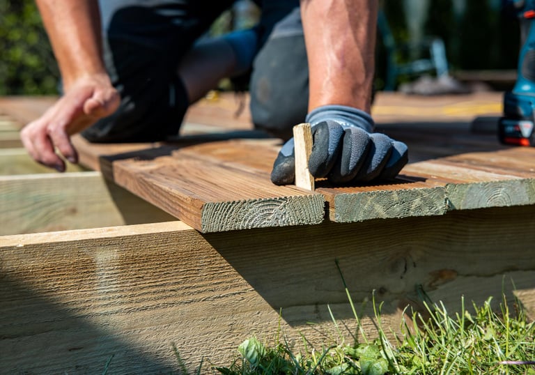 handyman repairing outdoor decking boards at an Auckland home