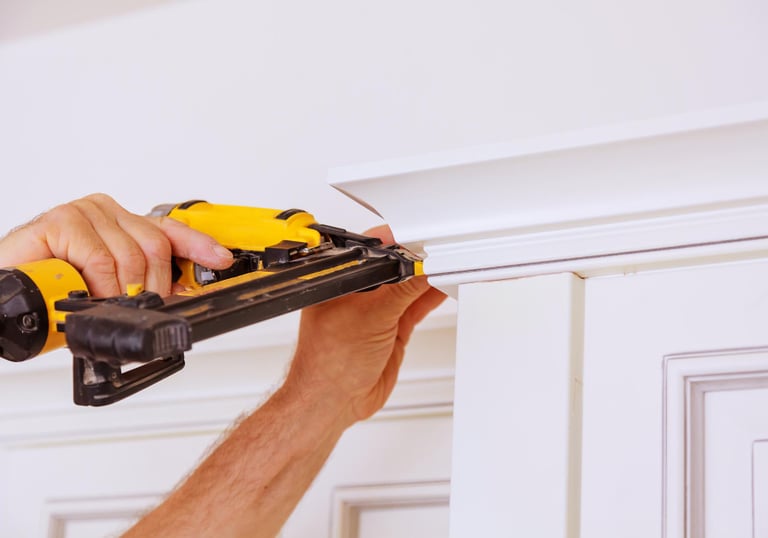 handyman repairing interior trim with a power drill in an Auckland home