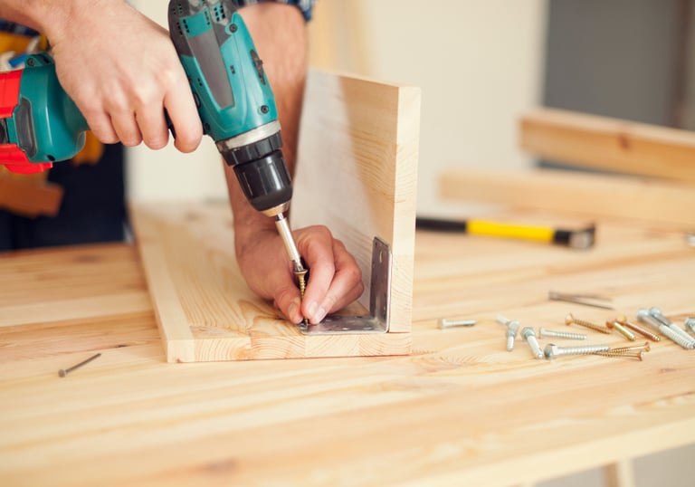 handyman assembling wooden furniture and fixtures in an Auckland workshop
