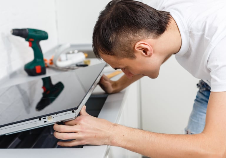 a man is looking at a stove to fix