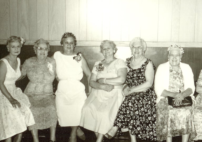 a group of women sitting on a bench in a room