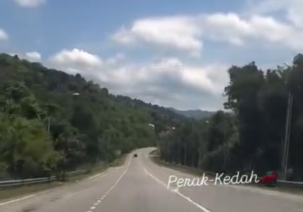 a car driving down a highway with a sky background
