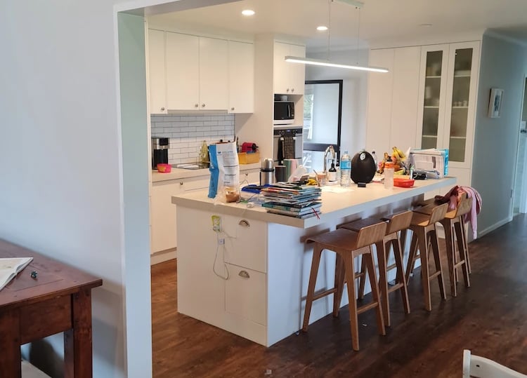 White kitchen with central island and wood floors, freshly painted by Gee Cee Painter
