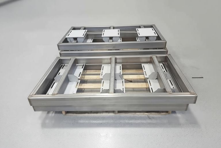 Custom fabricated industrial stainless steel metal frames complete and stacked on pallet.