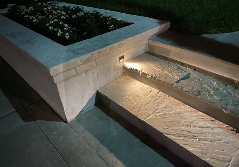 step light recessed in brick landscape planter box shining on a stone step
