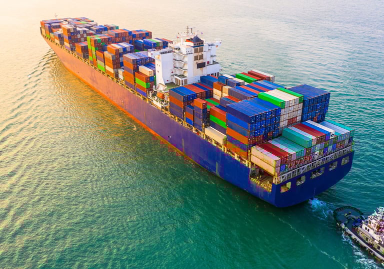 Aerial view of a large cargo container ship and tugboat navigating ocean waters for global logistics.