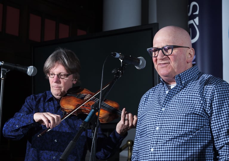 fiddler and singer performing with microphones