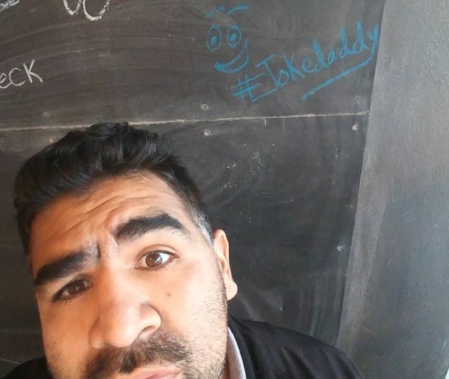 Joke Daddy standing in front of a chalkboard