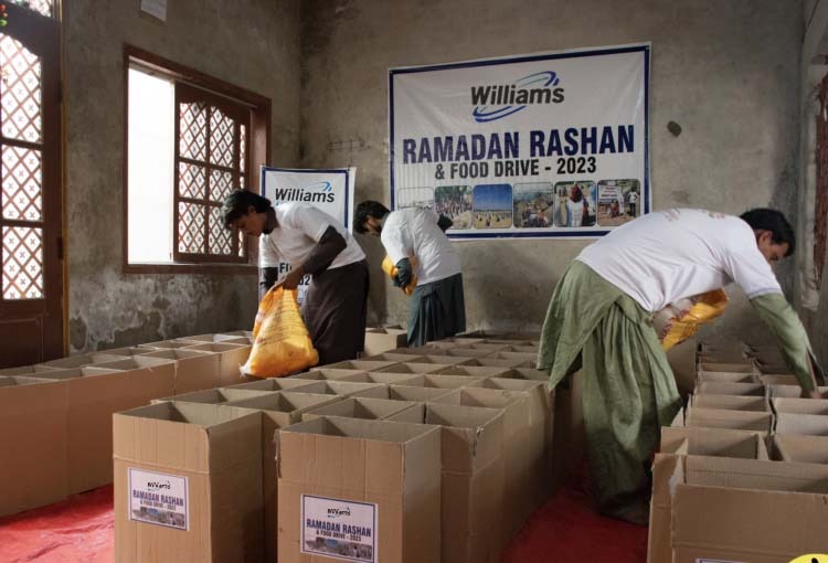 a group of people standing around boxes of food