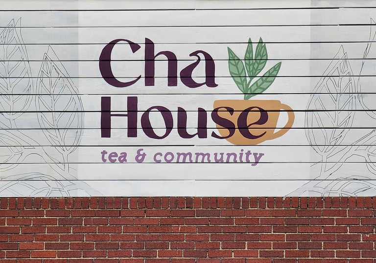 Cha House tea & community mural painted on a white wood wall.