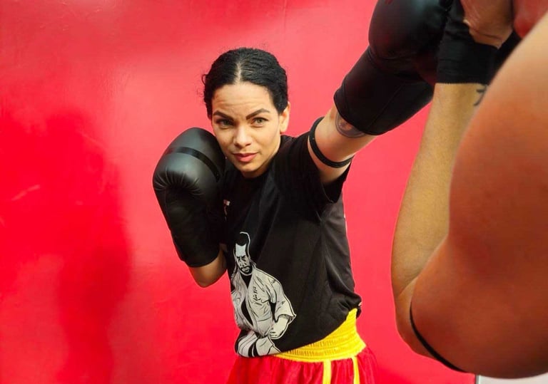 a woman in a boxing gloves is posing for a picture
