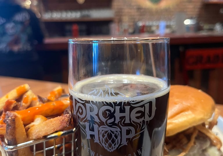A glass of dark craft beer, French fries, and a burger at Torched Hop Brewing Company in Atlanta.