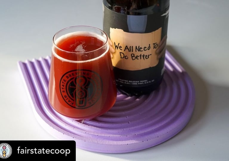 A glass of Fair State and Khonso red fruited Belgian tripel beer next to its bottle.