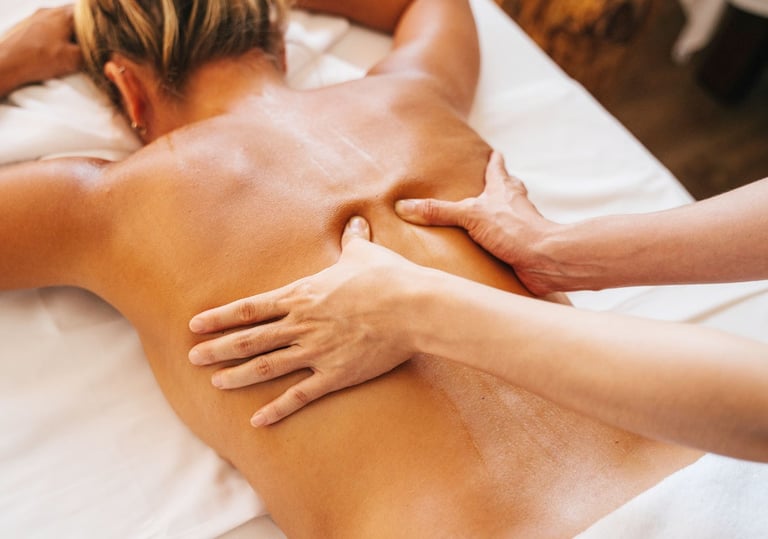 Masaje relajante de espalda aplicado manualmente sobre paciente tumbado boca abajo.