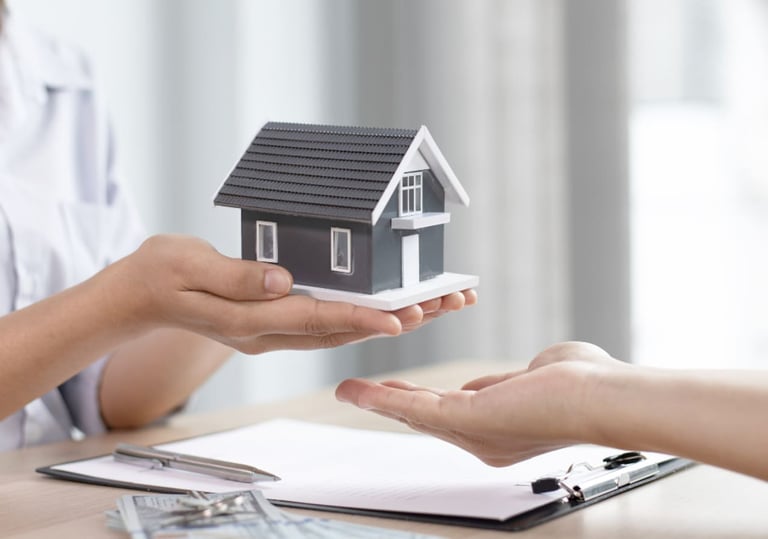 a woman holding a small house model FOR HOME LOANS PROMOTION