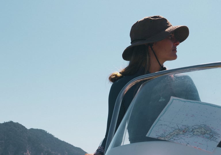 A scientist driving a boat while looking at a nautical map.
