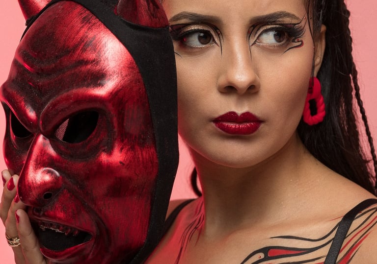 Fotografía conceptual de moda en Cancún. Modelo posando con máscara tradicional roja en estudio.