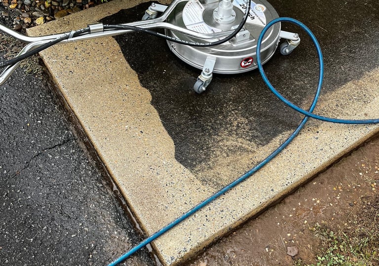 Pressure washing surface cleaner in action on dirty concrete driveway, Lenoir NC