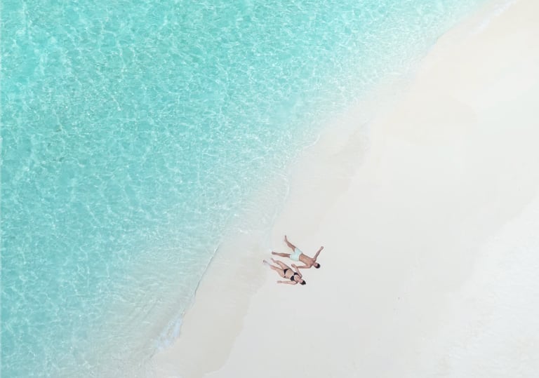 Customised your trip. A couple on a sandbank enjoy their private time with the nature, the ocean.