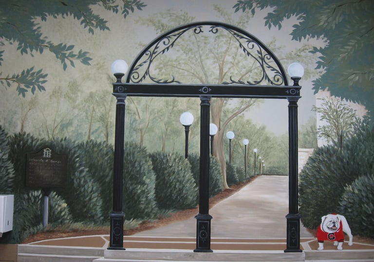 Mural of the University of Georgia Arch and Uga mascot bulldog on a campus walkway with lamp posts.