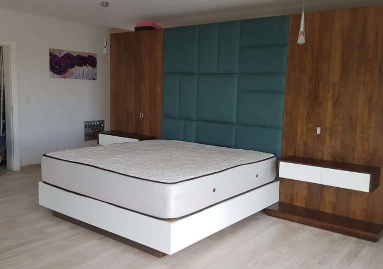 Diseño de dormitorio integrado con respaldo de cama, mesas de luz colgantes y box de cama