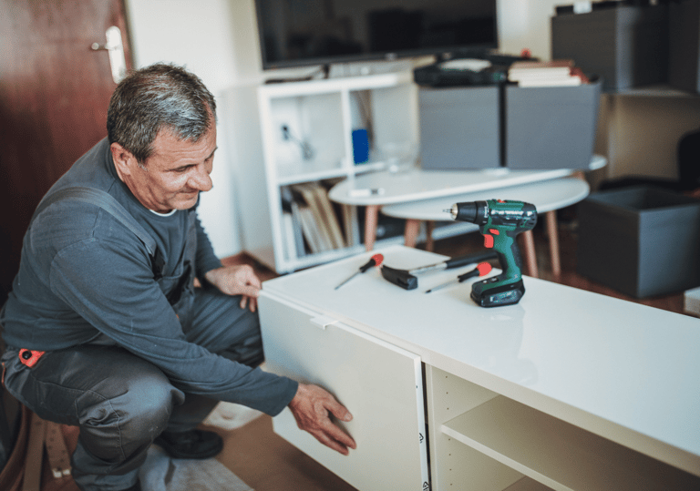 a man in a gray shirt is holding a drillet