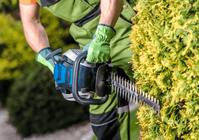 a man in a green shirt is holding a chainsawl