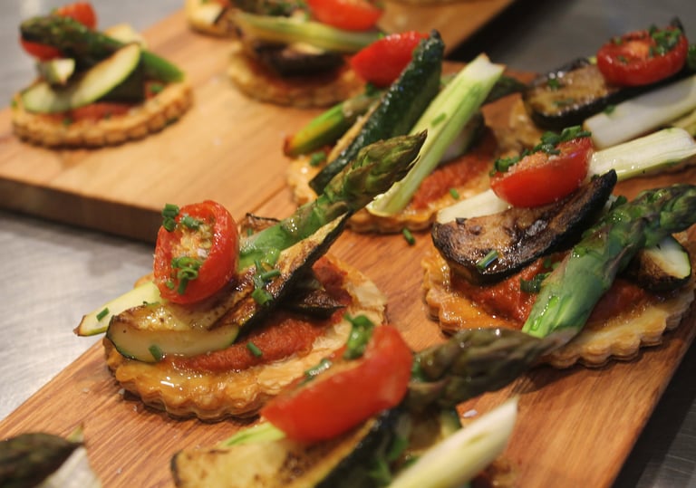 a wooden board with a variety of vegetables tart