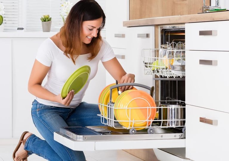 a women putting plates into a dishwasher