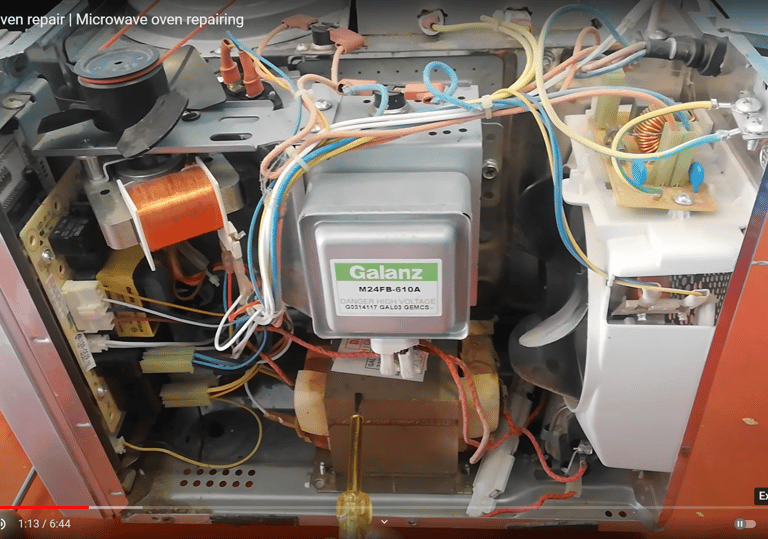 a picture showing internal component of a microwave. Magnetron and transformer is shown