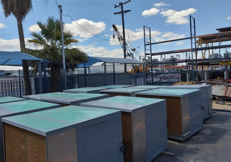 Enfriadores evaporativos industriales alineados en el patio de una maquiladora