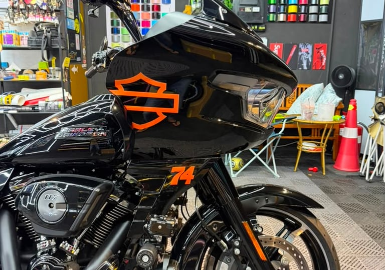 Harley-Davidson motorcycle with custom black and orange logo wrap