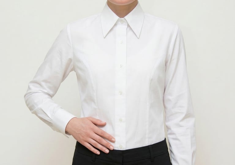 Mujer profesional con una clásica camisa blanca de manga larga abotonada y pantalones negros.