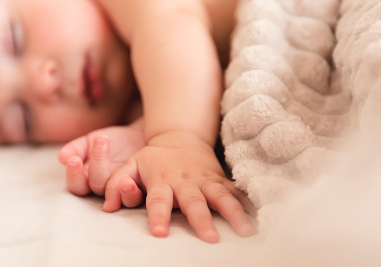 a baby is laying on a bed with a blanket