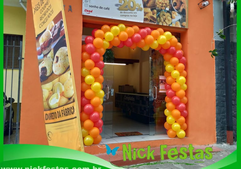 Arco de balões decorando entrada de loja em inauguração com cores personalizadas.