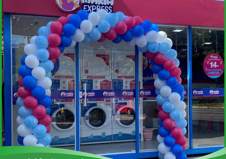 Arco de balões elegante em evento corporativo, destacando fachada da empresa.