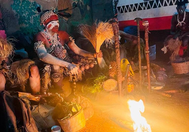 a group of people sitting around a fire. Bwiti ceremony