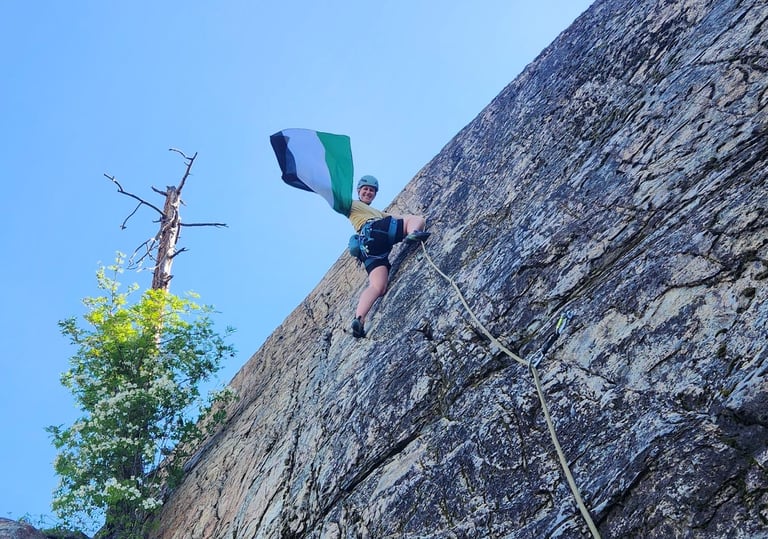 A climber halfway up the wall waving a Palestinian flag