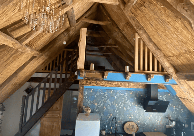 Livingroom sous les combles et le toit en chaume, mezzanine et escalier