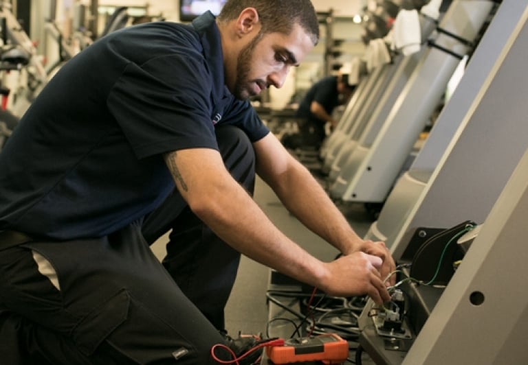 a man in a gym room with a bike