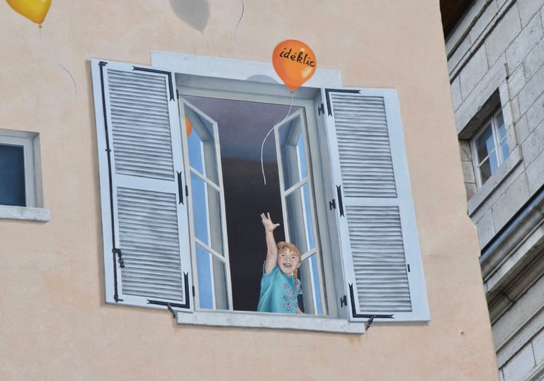 Détail d'un trompe-l'oeil sur façade à Moirans-en-Montagne: Une fillette à une fenêtre au 1er étage.