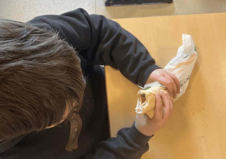 élève qui mange un sandwich