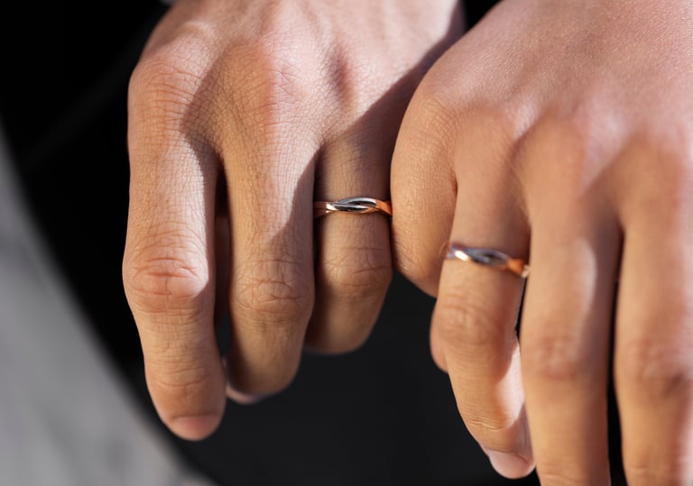 a man and woman's hands holding wedding rings