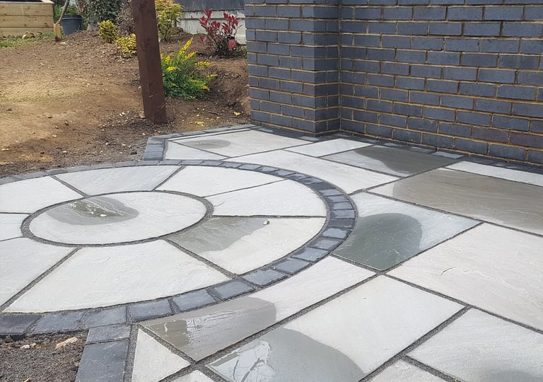 Grey sandstone circle paving slabs with charcoal edging