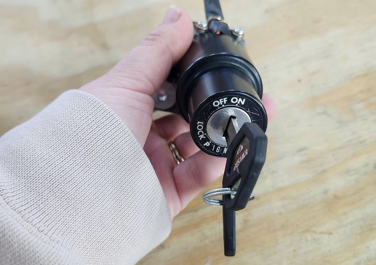 Close up holding motorcycle key in the ignition representing motorcycle locksmith services in Biltmore, NC